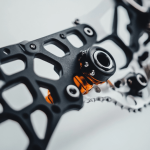 A close-up of a complex mechanical part with a black and orange color scheme