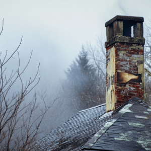 Smoky chimney in winter landscape